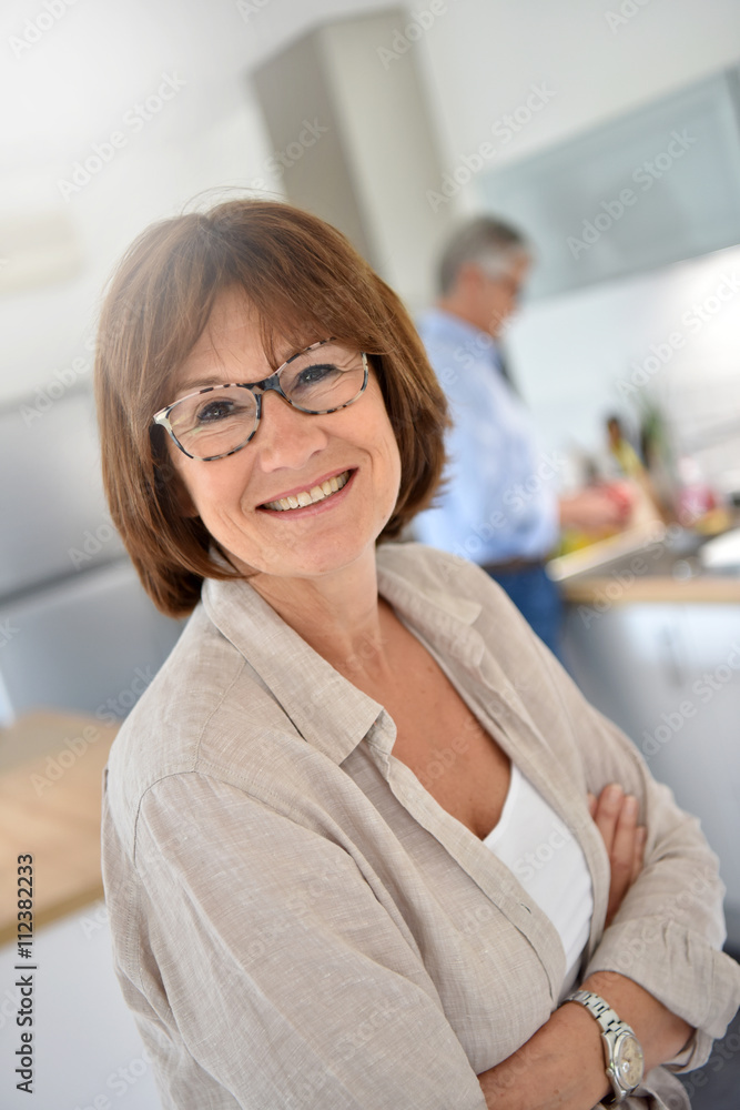Portrait of smiling senior woman, husband in background Portrait of smiling senior woman, husband in background