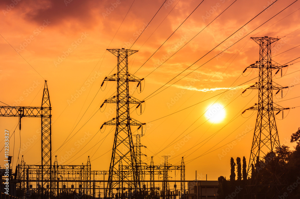high voltage electric pillars in substation on sunset background Stock