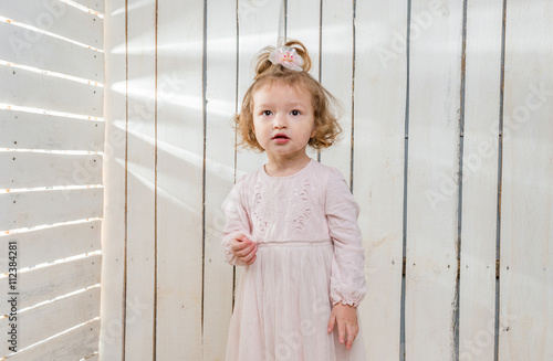 funny stylish little girl in fluffu skirt sitting on the floor in wooden studio photo