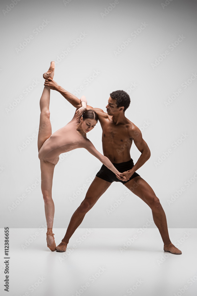 Naklejka premium Couple of ballet dancers posing over gray background