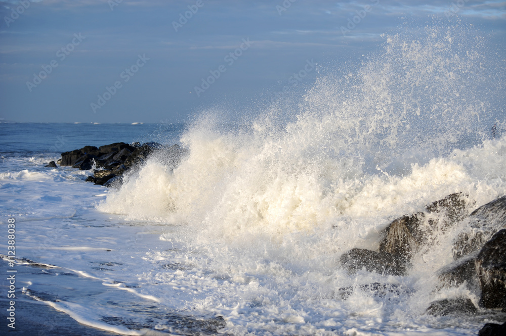 Fototapeta premium welle bricht über Steinmole
