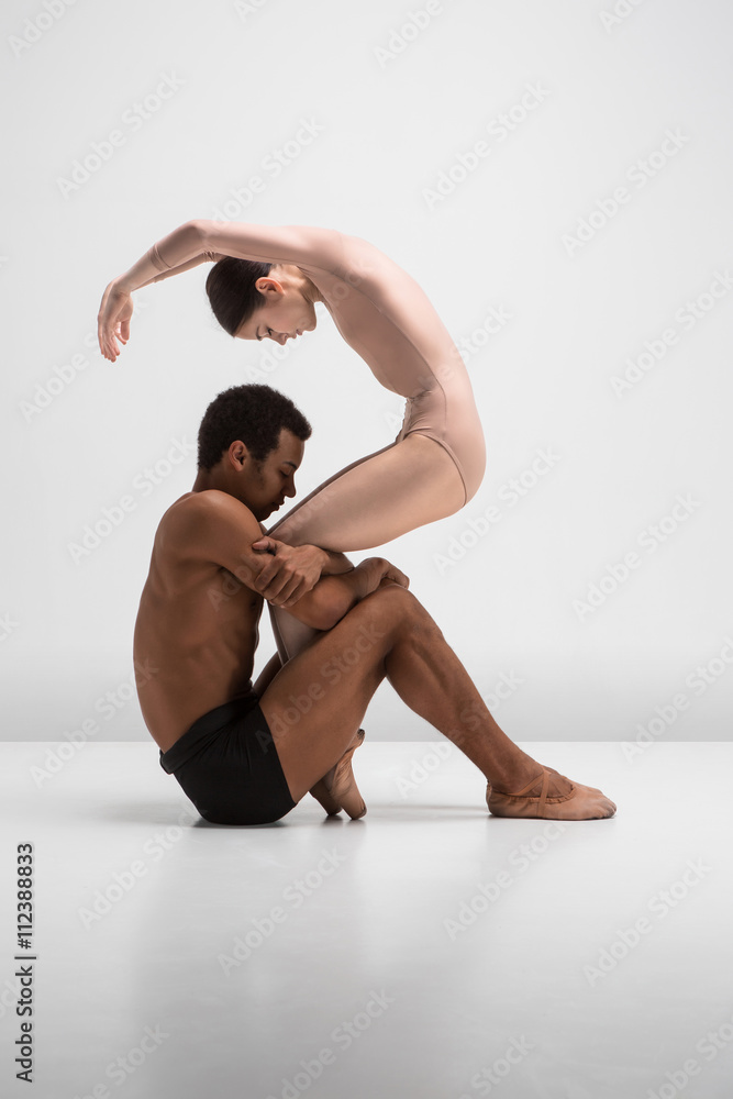 Naklejka premium Couple of ballet dancers posing over gray background