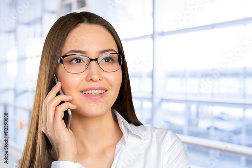 Young, confident, successful and beautiful business woman with the mobile phone isolated