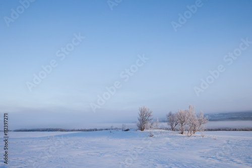nebliger Morgen an einem zugefrorenen See in Schweden
