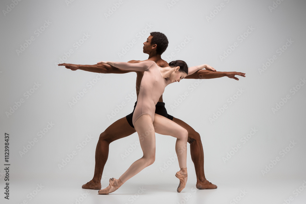 Obraz premium Couple of ballet dancers posing over gray background