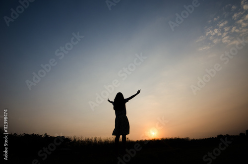 Silhouette of a girl gesture happy with the golden light of the sunset, © photobyphotoboy