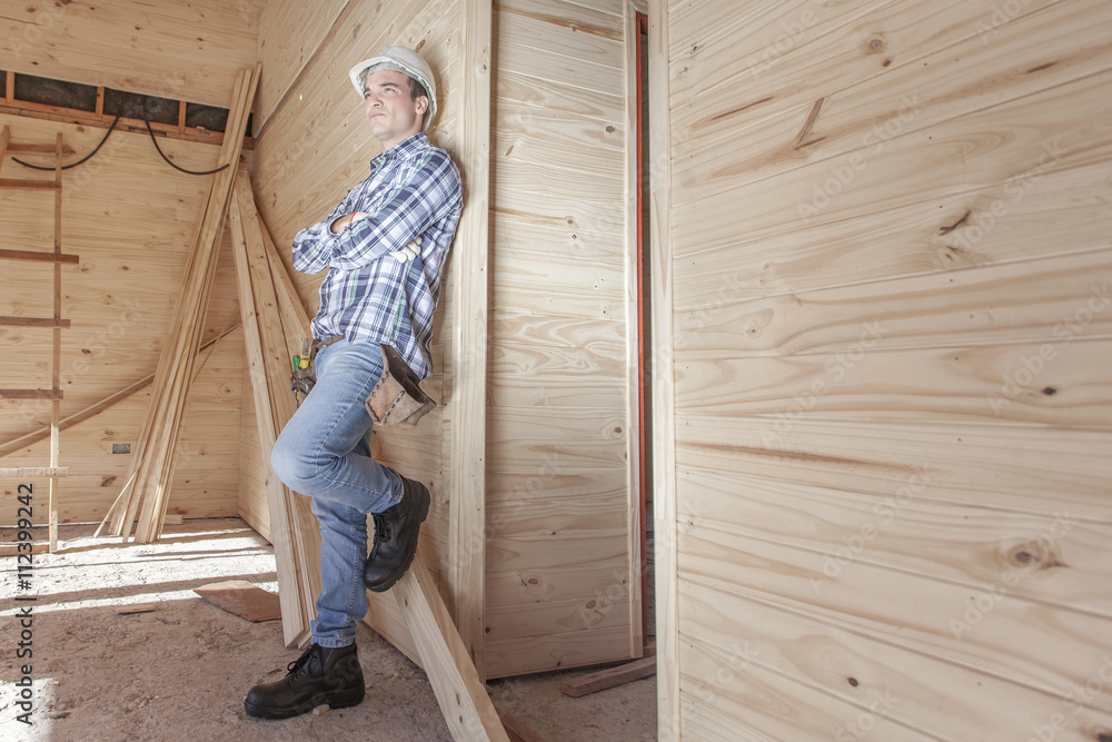 Contractor leaning against wooden wall
