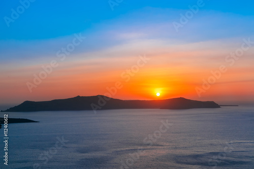 Beautiful vibrant sunset over the sea and island Thirasia  Santorini  Greece