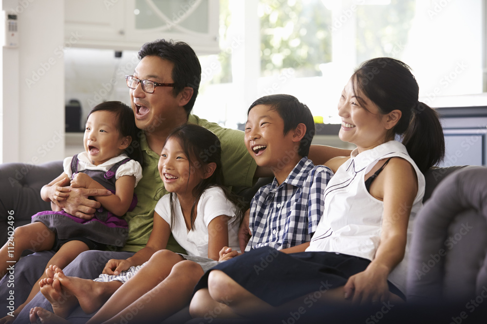 Family Sitting On Sofa At Home Watching TV Together Family Sitting On Sofa At Home Watching TV Together