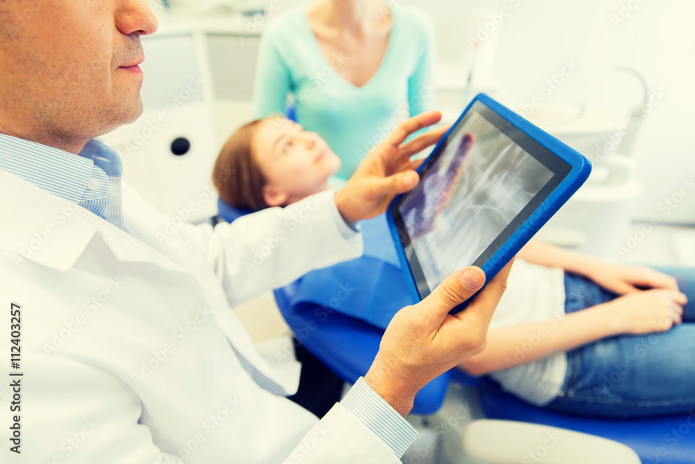 dentist with x-ray on tablet pc with patient girl dentist with x-ray on tablet pc with patient girl