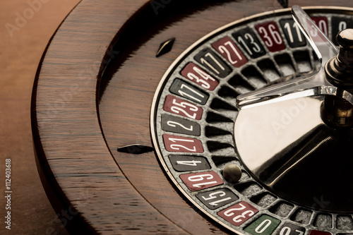 Roulette in legno su sfondo tavolo con pallina sul numero 19 photo