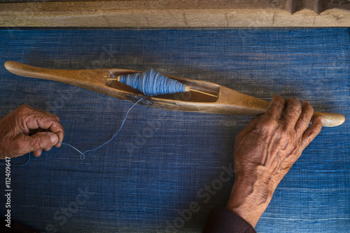 A woman weaving textiles dyed with indigo
