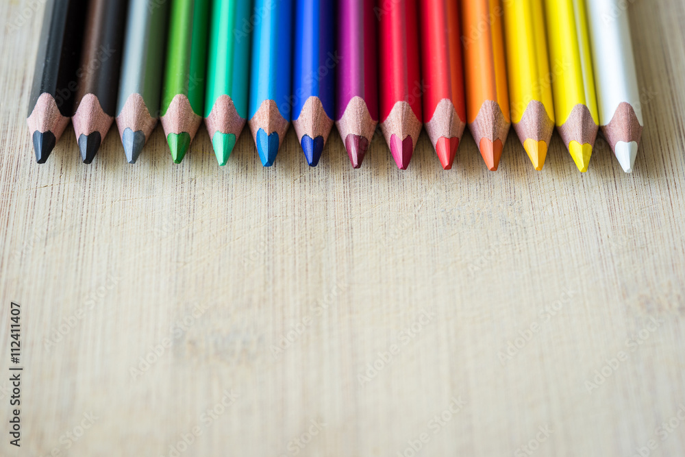 Obraz premium Color Pencils on wood texture. Macro shot of colorful pencils. Horizontal view of pencils.
