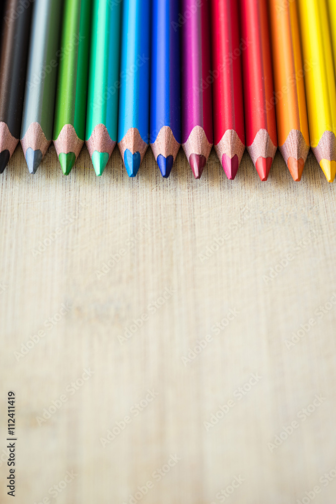 Obraz premium Color Pencils on wood texture. Macro shot of colorful pencils. Vertical view of pencils.