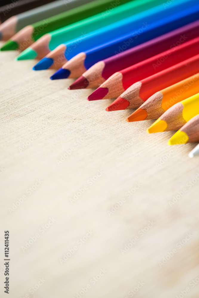 Obraz premium Color Pencils on wood texture. Macro shot of colorful pencils. Vertical view of pencils. Selective focus.