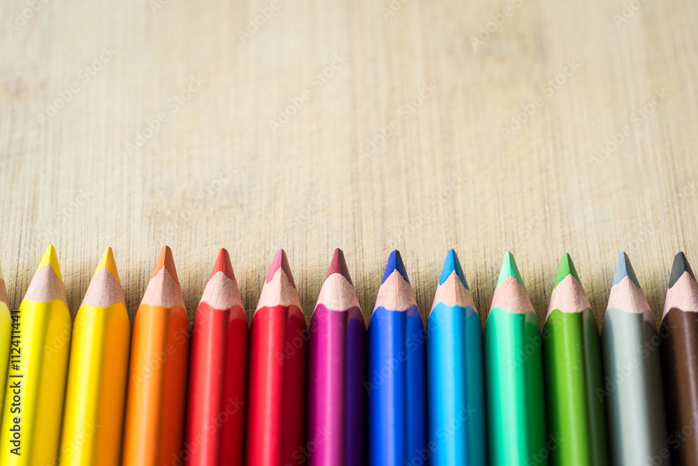 Obraz premium Color Pencils on wood texture. Macro shot of colorful pencils. Horizontal view of pencils.