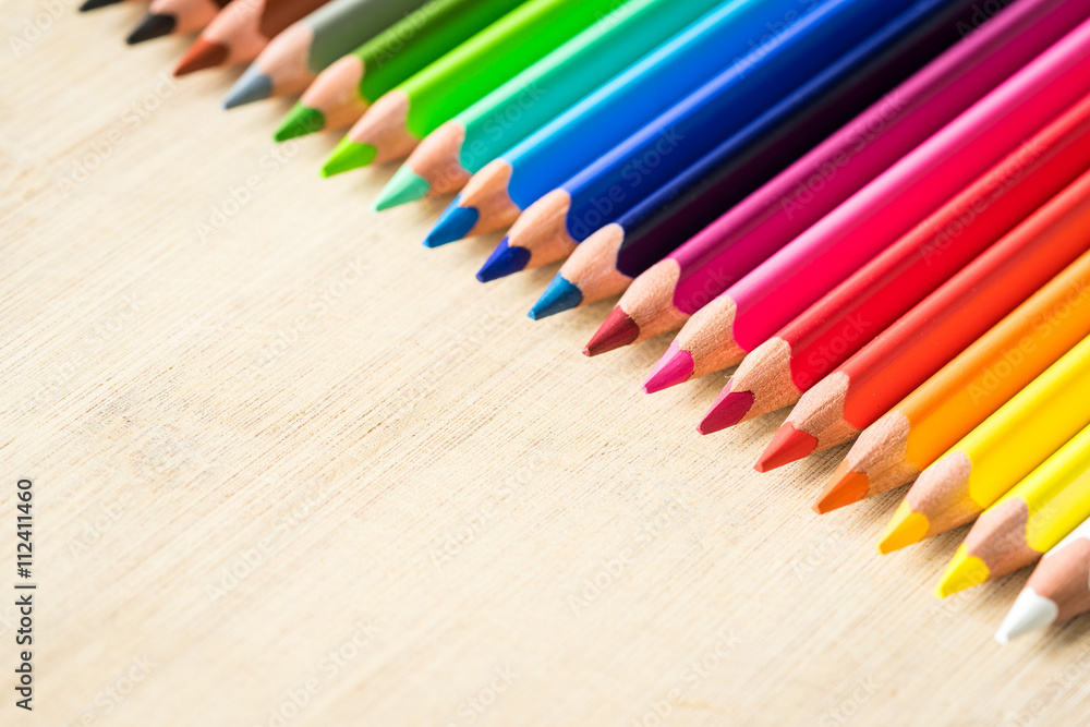 Obraz premium Color Pencils on wood texture. Macro shot of colorful pencils. Horizontal view of pencils.
