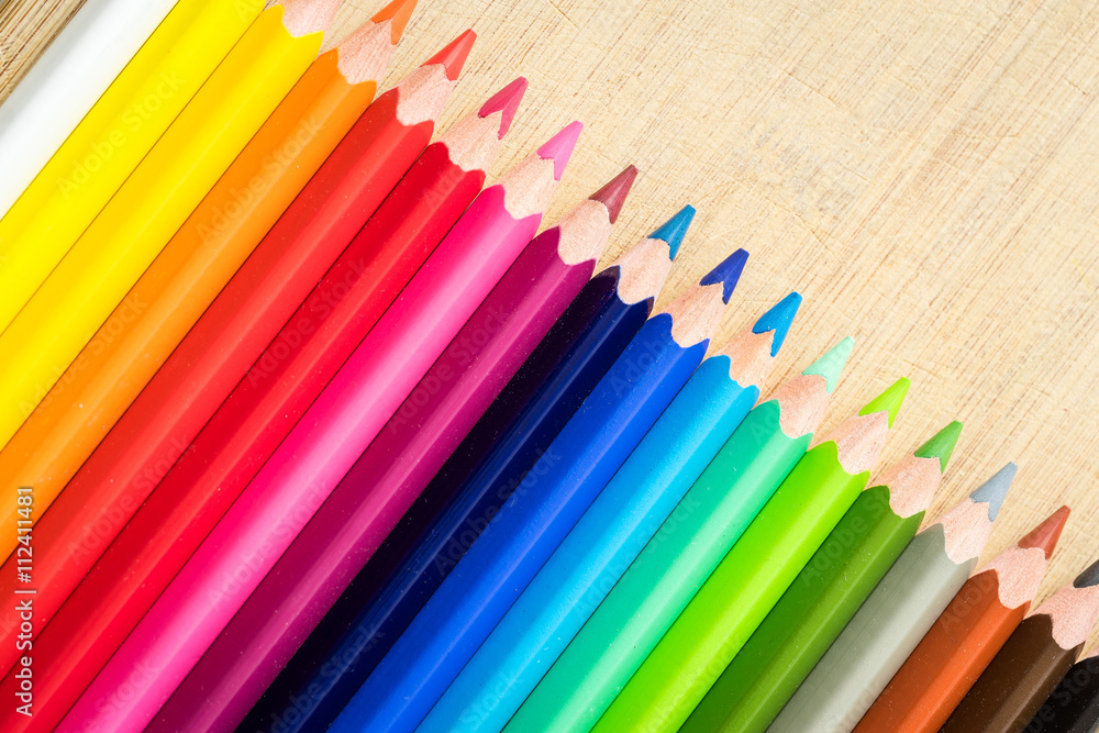 Obraz premium Color Pencils on wood texture. Macro shot of colorful pencils. Horizontal view of pencils.
