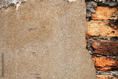 Old damaged brick wall with plaster