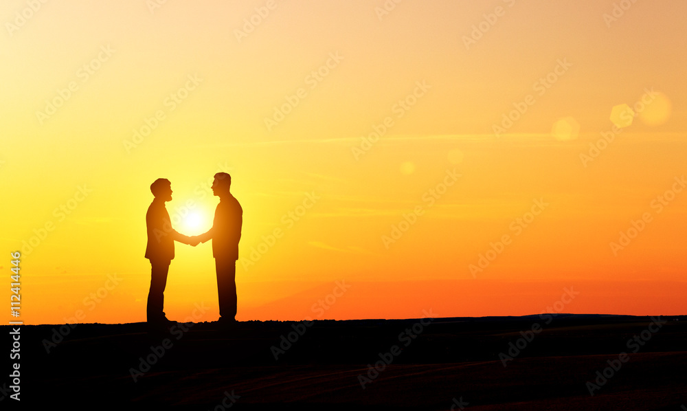 Men silhouettes shaking hands