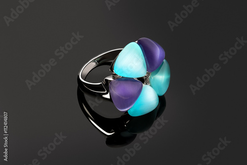 Jewelry flower shaped silver ring with colored topazes on grey b photo