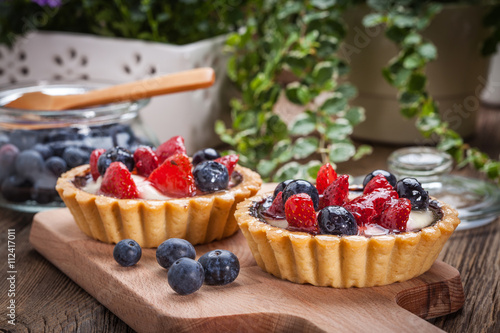 Fotografie, Obraz Fresh homemade fruit tart with strawberries and blueberries.