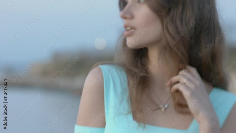 Beautiful girl in the blue dress standing by the sea Beautiful girl in the blue dress standing by the sea