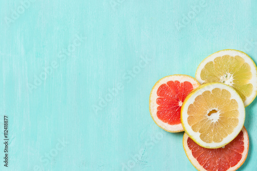 Top view on cut red and yellow grapefruit on a turquoise wooden background. Juicy and fresh fruit. Healthy eating concept.