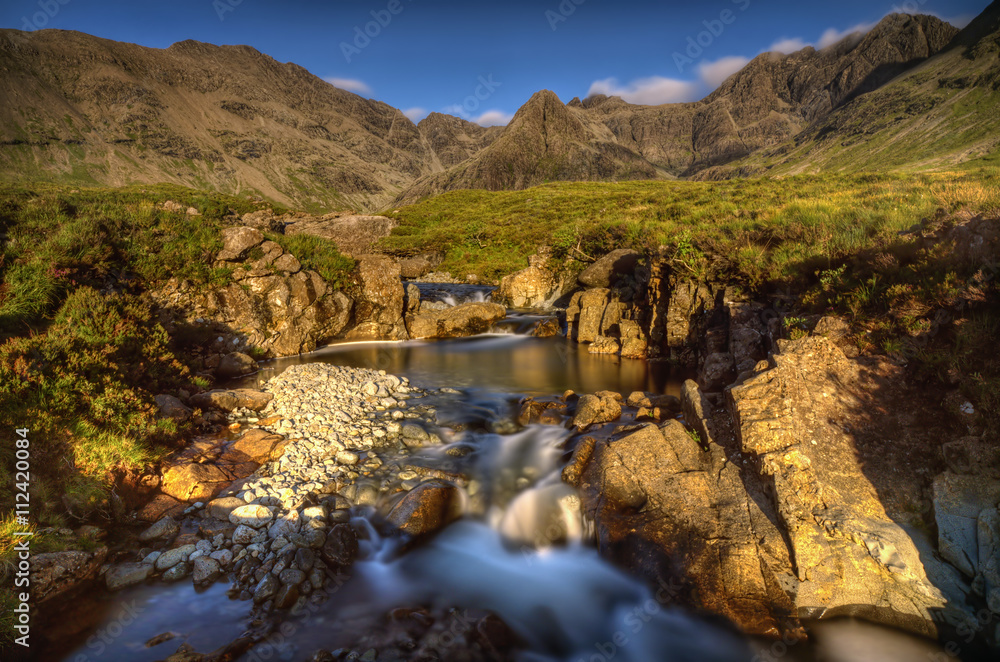 Fairy Pools waterfalls with Sgurr an Fheadain and Cuillin Mountains in sunset light, Isle of Skye, Scotland Fairy Pools waterfalls with Sgurr an Fheadain and Cuillin Mountains in sunset light, Isle of Skye, Scotland