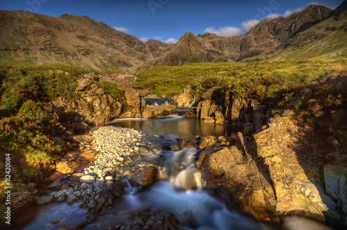 Fairy Pools waterfalls with Sgurr an Fheadain and Cuillin Mountains in sunset light, Isle of Skye, Scotland