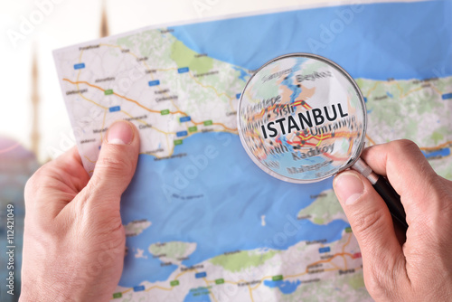 Canvas Print Man consulting a map of Istanbul with a magnifying glass