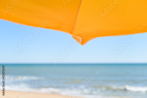 Holiday view of sun umbrella  sandy beach and ocean shore background