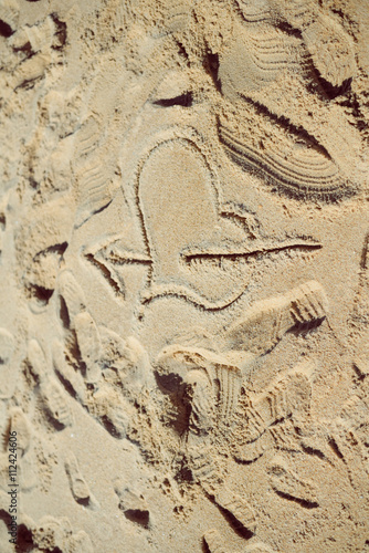 Love heart and arrow drawing in the beach sand. 