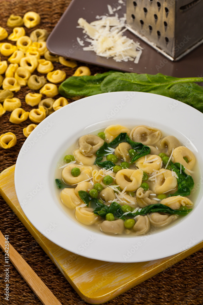 Tortellini Soup with Peas and Spinach. Selective focus.
