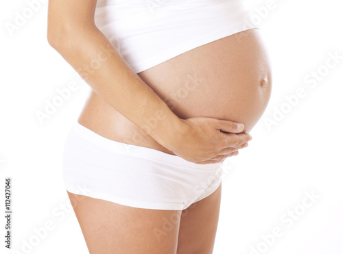 Pregnant woman hugging her belly.