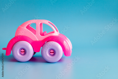 Photos Colorful plastic toy car on a blue background for children.