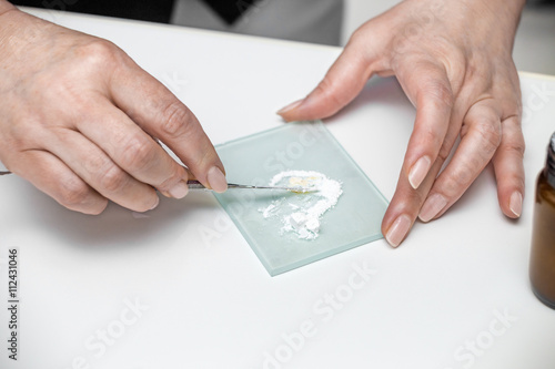 Woman's hands with dental tool   mixing white cement