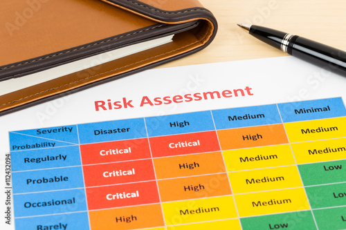 Risk management matrix chart with pen and organizer book; docume