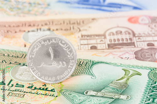 United Arub Emirates dirham coin stand on banknote money