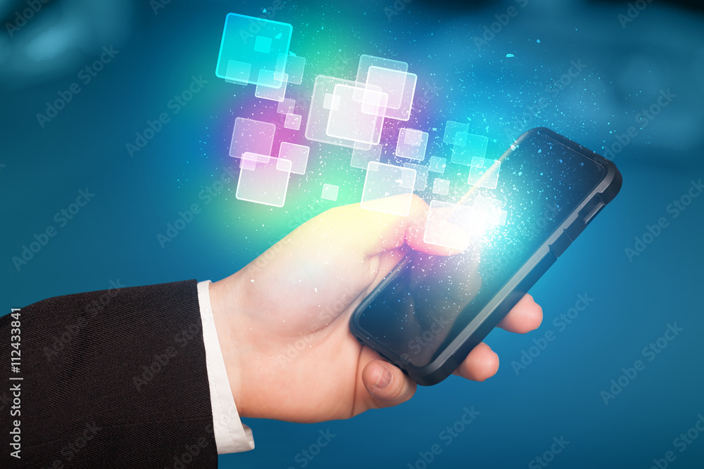 Hand holding smart phone with abstract glowing squares Hand holding smart phone with abstract glowing squares