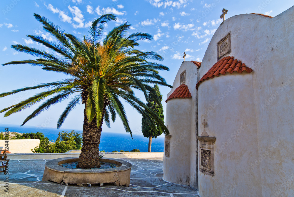 Church buildings, palm and cypress trees inside Preveli monastery, island of Crete, Greece