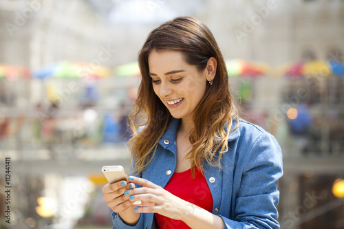 Young brunette woman reading a message on the phone