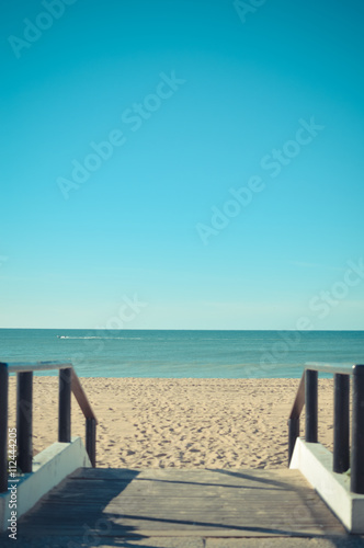 Fototapeta Naklejka Na Ścianę i Meble -  Sandy beach with wooden walkway on sunny day background