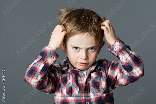 Foto unhappy kid scratching his hair for head lice or allergies