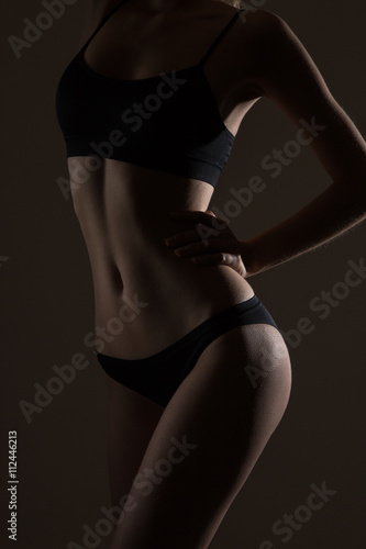silhouette of slim woman body in black low key