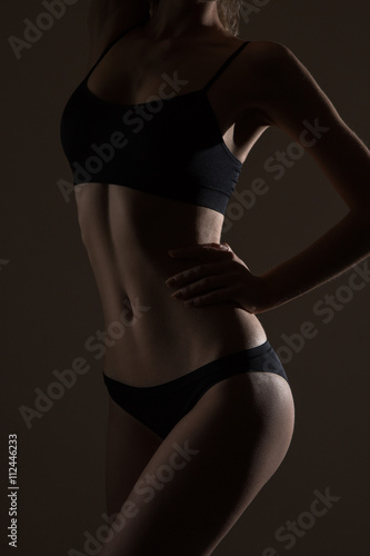 silhouette of slim woman body in black low key