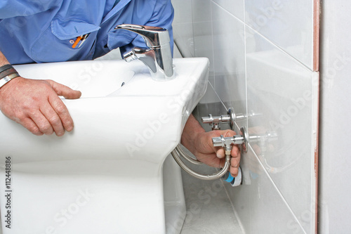Construction worker installing bidet