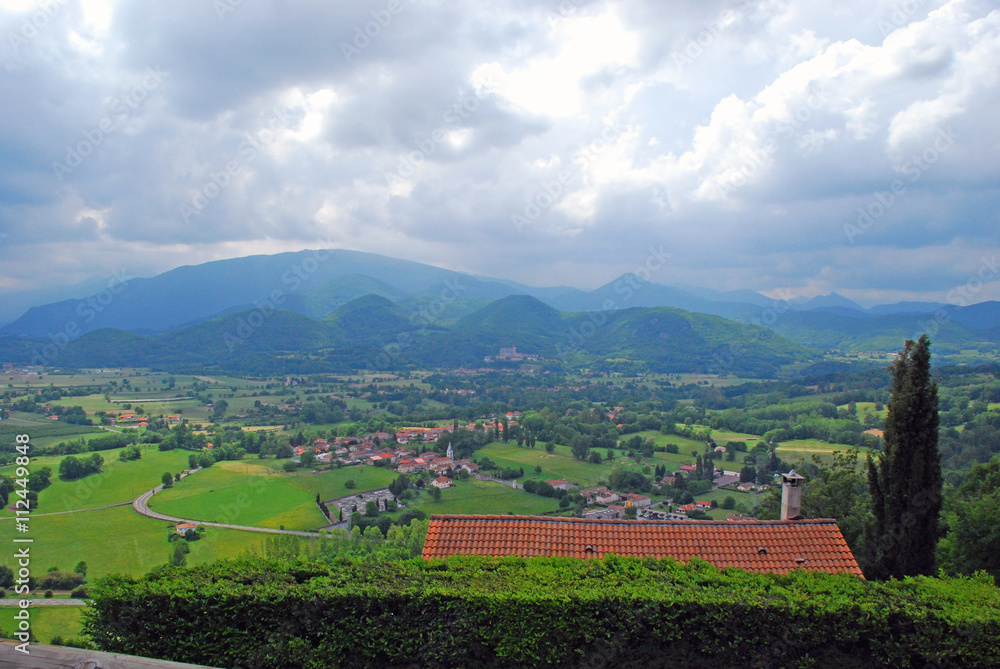 Naklejka premium On the foreground we can see various house roofs and in the background hills of Haute-Garonne countryside in the south of France. 