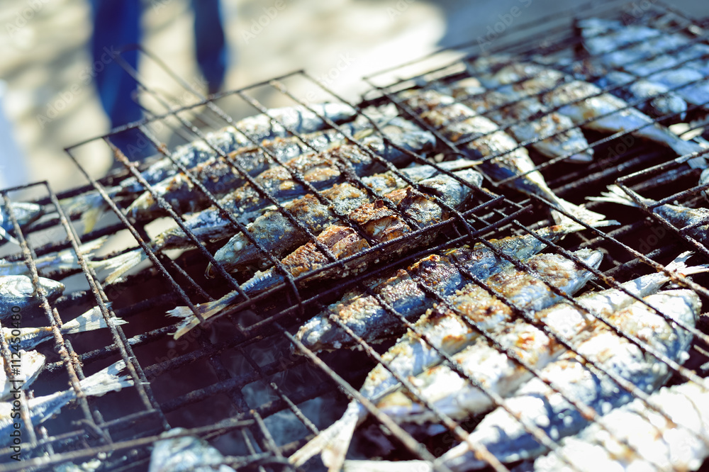 Top view on grilling fish on barbecue, background outdoors