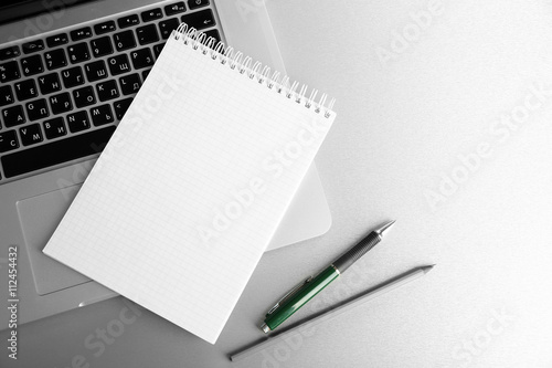Empty  notebook on laptop keyboard  on light background